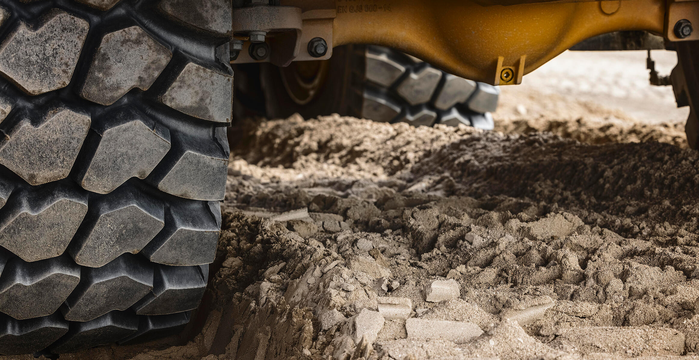 Close up of the wheels and axles of a Volvo Articulated Hauler driving confidently through deep mud