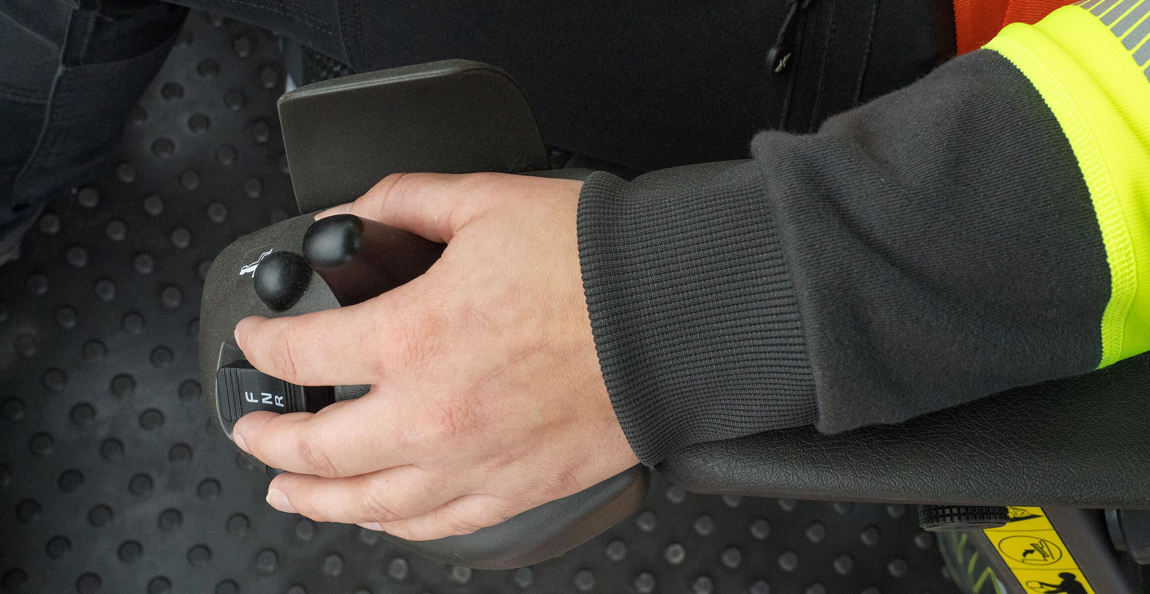 Operator hand controlling comfort drive control lever in Volvo L220 wheel loader