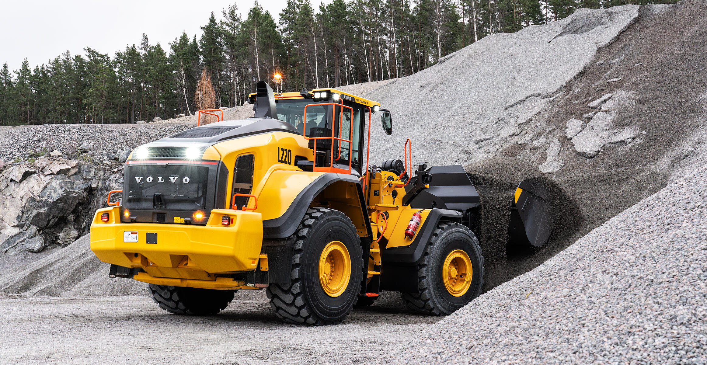 Lights on at the rear of L220 Volvo Wheel Loader as it loads from pile