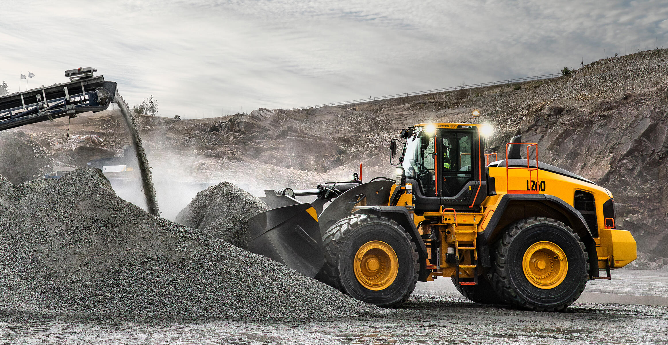 Three large buckets in front of L260 Volvo wheel loader in quarry