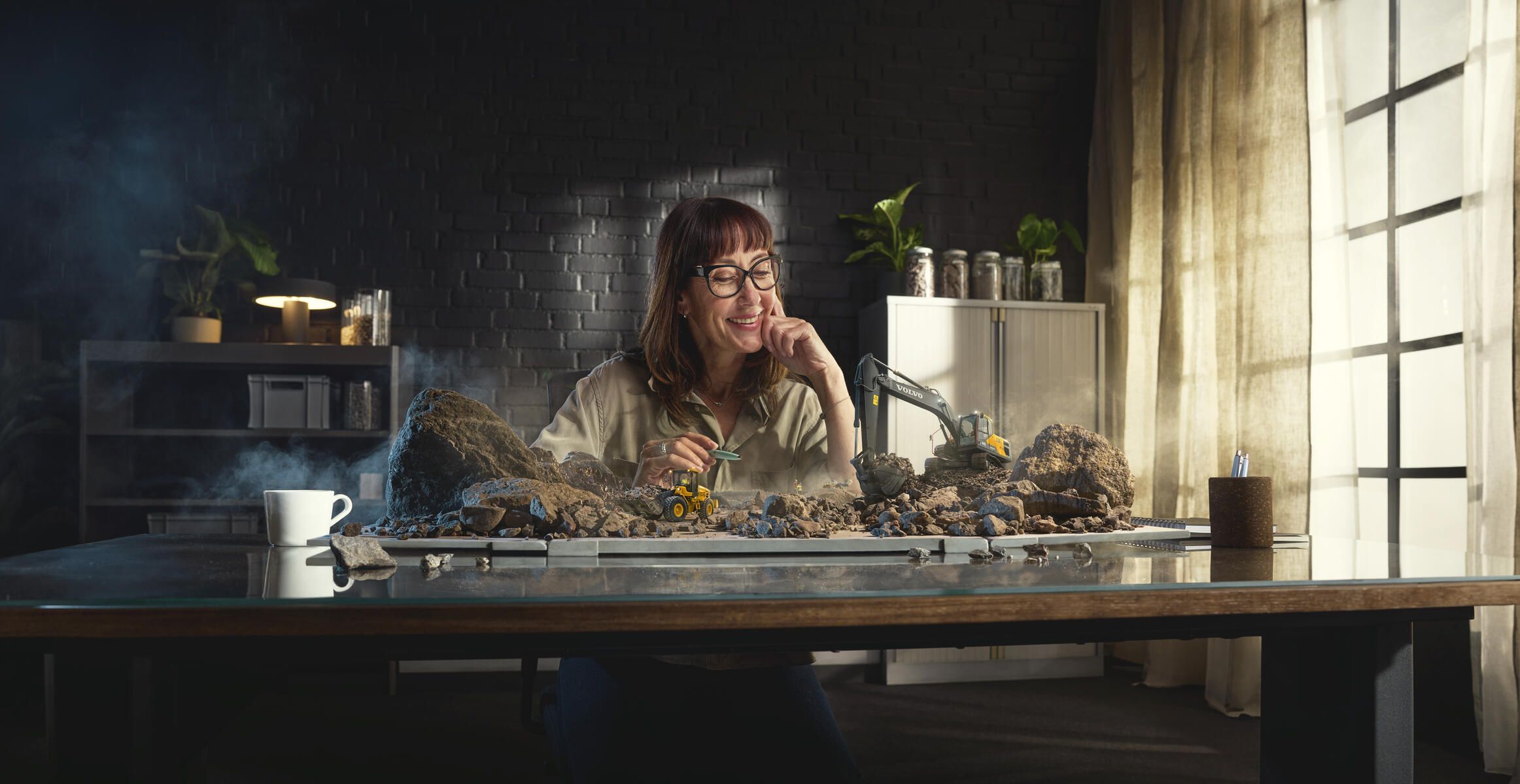 Lady working at desk with all Volvo Construction Equipment smarter solutions working in front of her