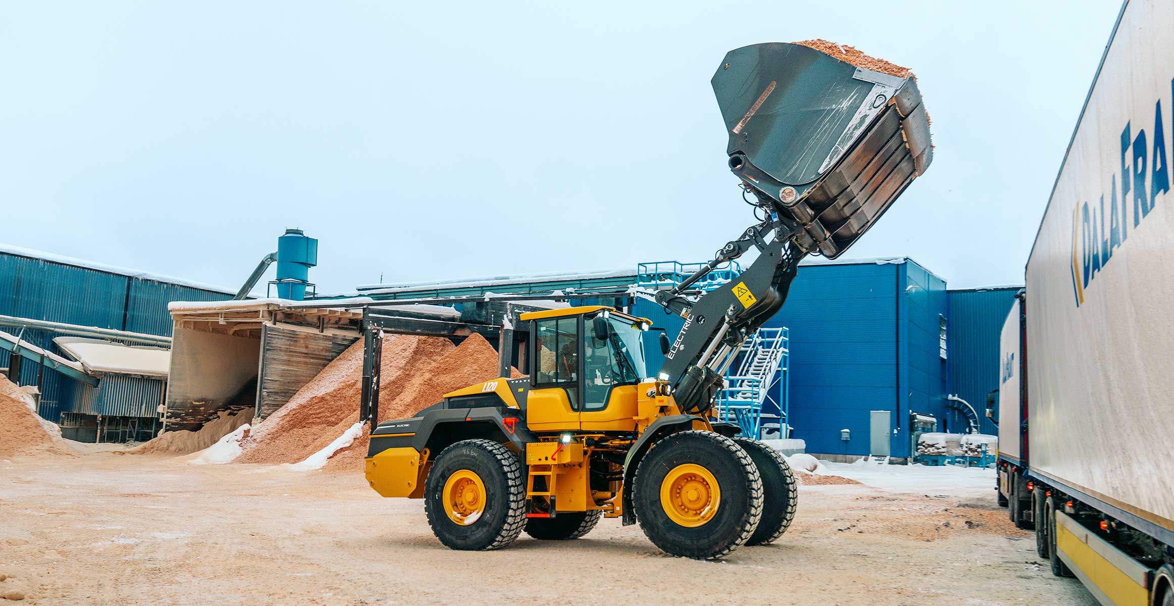 Volvo L120 Electric loading wood chips and sawdust into a truck at Fiskarheden, Dalarna, Sweden